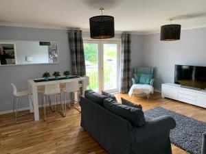 a living room with a couch and a table and a tv at Flat Five, 212 Eaglesham Road, East Kilbride, Glasgow in East Kilbride