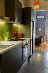 Soho Apartments في أثينا: مطبخ بجدران سوداء وأخضر ومغسلة