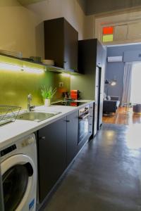 Il comprend une cuisine équipée d'un évier et d'un lave-linge. dans l'établissement Soho Apartments, à Athènes