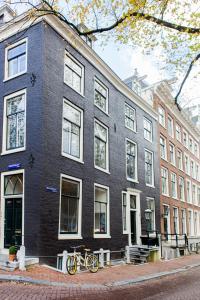 un bâtiment noir avec deux vélos garés devant lui dans l'établissement Mokum Suites, à Amsterdam