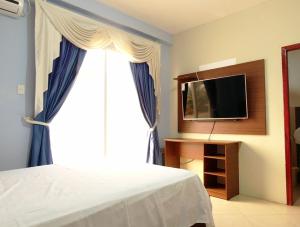 1 dormitorio con 1 cama y ventana con TV en Hotel Sea World, en San Jacinto