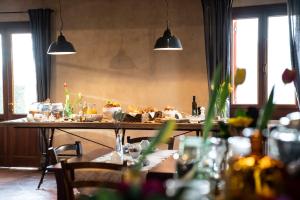 un tavolo con cibo sopra in una stanza con finestre di Foresteria Borgoluce a Susegana