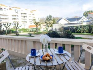a table with a plate of food on a balcony at Apartment de la Plage et d'Angleterre by Interhome in Royan