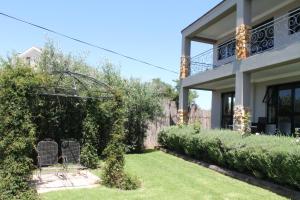 a yard of a house with a chair and a garden at Stone Olive in Jeffreys Bay