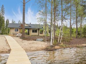 a home with a wooden bridge over a river at Holiday Home Villa puronotko by Interhome in Pertunmaa