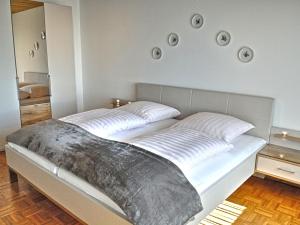 Apartment Belvedere by Interhome في ماندرشايد: سريرين في غرفة نوم وصحنين على الحائط
