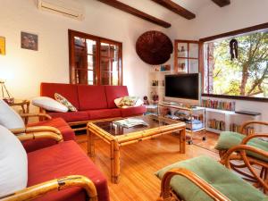 sala de estar con sofás rojos y TV en Holiday Home La Plaza by Interhome, en Calonge