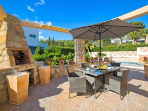 een patio met een tafel en een parasol bij Holiday Home Nadine by Interhome in Casas de Torrat