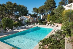 una piscina en un patio con sillas y una casa en Can Botana 3, en Cala de Sant Vicent