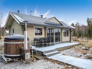 a house with a wooden deck with a hot tub at Holiday Home Villa puronotko by Interhome in Pertunmaa