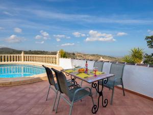 a patio with a table and chairs next to a pool at Villa Robinson by Interhome in Pedreguer