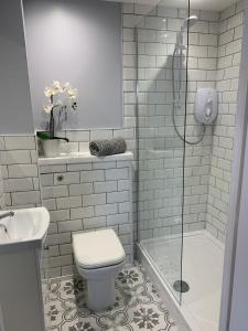 y baño con aseo, lavabo y ducha. en Flat One, 212 Eaglesham Road, East Kilbride, Glasgow en Glasgow