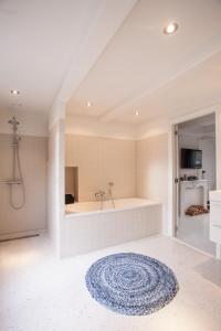 La salle de bains est pourvue d'une baignoire et d'un tapis bleu. dans l'établissement Mokum Suites, à Amsterdam