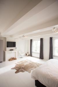 a white bedroom with a bed and a bathroom at Mokum Suites in Amsterdam