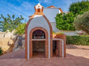 un horno de pizza de ladrillo frente a una casa en Villa Robinson by Interhome en Pedreguer