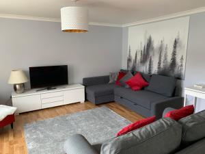a living room with a couch and a tv at Flat One, 212 Eaglesham Road, East Kilbride, Glasgow in Glasgow