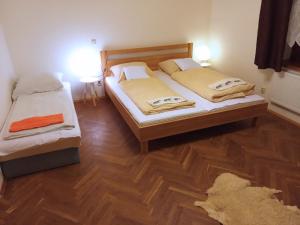 two twin beds in a room with wooden floors at Apartmán U Zebry in Bílá Třemešná