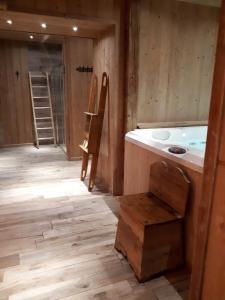 a bathroom with a tub and a wooden floor at Hotel Riva Sport & Wellness in Vione