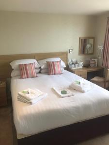a bedroom with a bed with two towels on it at Monarch Hotel in Bridlington