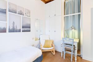 1 dormitorio con cama, escritorio y silla en Florence City Center Flat Via Dei Neri, en Florencia
