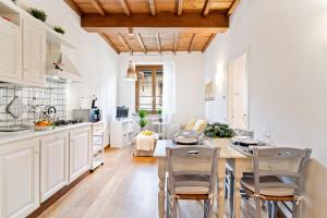 a kitchen with white cabinets and a table and chairs at Florence City Center Flat Via Dei Neri in Florence