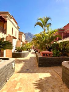una strada con edifici e palme in una città di Villa Del Duque with private pool ad Adeje