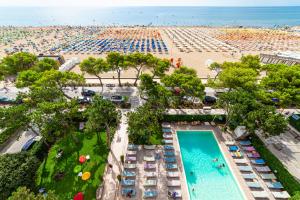 an aerial view of a beach with a pool and beach umbrellas at American Hotel in Lignano Sabbiadoro