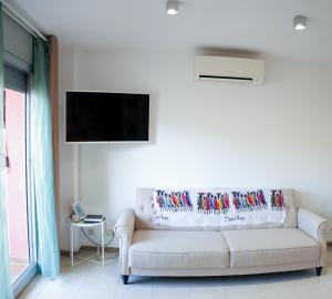 a living room with a white couch and a flat screen tv at Mataro Luxury Apartments in Mataró