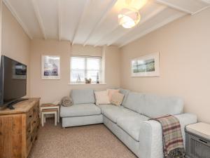 a living room with a couch and a tv at The Granary - Rhoscolyn in Holyhead