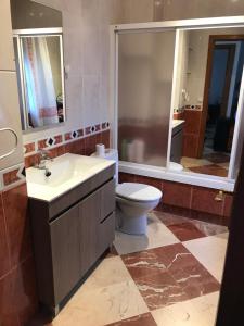Un baño con inodoro, lavabo y espejo. en Casa Marta, en Setenil 28 fotos más