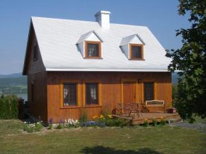 a small house with a white roof and a porch at Au Vieux Foyer, Gîte & Chalets in St-Pierre-de-l'Île-d'Orléans