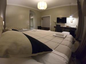 a bedroom with a large white bed with a desk at Residenza Roma Imperiale in Rome