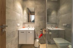 bagno con 2 lavandini, servizi igienici e specchio di COMFORTABLE & ELEGANT FLAT IN A LIVELY PLACE a Casablanca