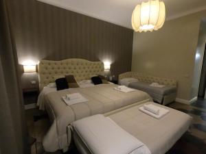a hotel room with two beds and two tables at Residenza Roma Imperiale in Rome