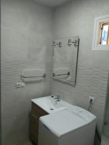 a white bathroom with a sink and a mirror at Casa Sardinero in Torremolinos