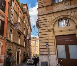 a man walking down a street next to a tall building at Hotel Rinascimento - Gruppo Trevi Hotels in Rome