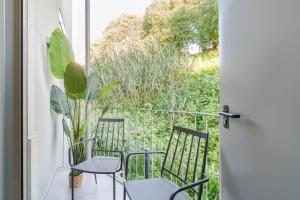 un balcón con 2 sillas y una planta en Casa Boma Lisboa - Modern & Luminous Apartment with Balcony - Alcantara I, en Lisboa