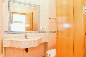 La salle de bains est pourvue d'un lavabo, de toilettes et d'un miroir. dans l'établissement Veleiro Verde, à Monte Gordo