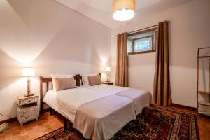 沃澤拉的住宿－Quinta das Lamas - Antiga Adega，卧室配有一张白色大床