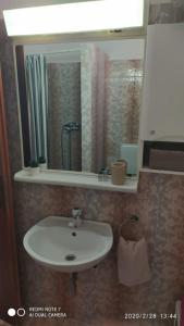 ein Bad mit einem Waschbecken und einem Spiegel in der Unterkunft Studio apartment Marčelina in Preko