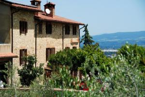 an old stone building with trees in front of it at Antico Casolare in Marsciano