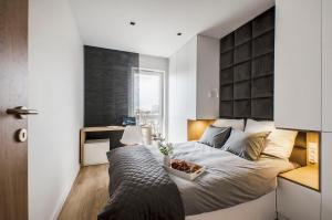 una camera da letto con un letto e una ciotola di cibo sopra di SKY Home- Ilumino Apartment -Centrum, Parking, Klimatyzacja, Dostęp na Kod a Łódź