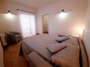 Un dormitorio con una cama grande con dos almohadas encima. en Mignola Le Bozze- Podere con piscina-WI-FI, en Castagneto Carducci