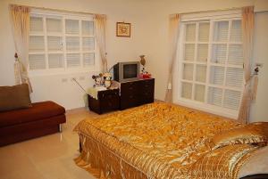 - une chambre avec un lit, une télévision et des fenêtres dans l'établissement Harmony Village, à Wujie