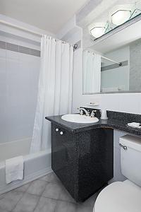 a bathroom with a sink and a toilet and a mirror at Murray Hill East Suites in New York