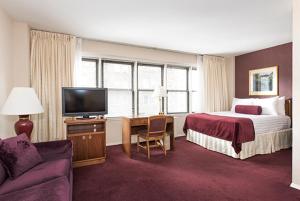 ein Hotelzimmer mit einem Bett und einem TV in der Unterkunft Murray Hill East Suites in New York