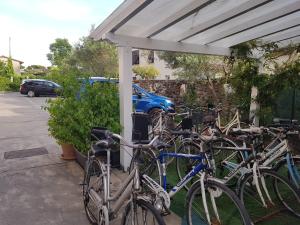 een groep fietsen geparkeerd onder een witte luifel bij Hotel Patrizia in Marina di Massa