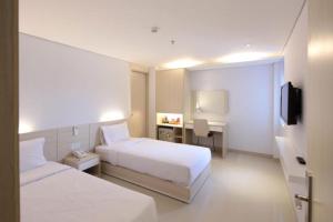 a hotel room with two beds and a television at Tristar Hotel in Nha Trang