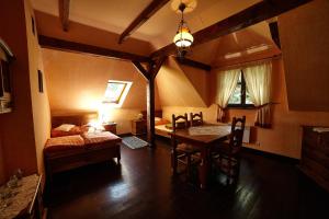 a room with a bed and a table and a bed and a bedroom at Stylowy Zajazd Pod Czarnym Kogutem in Czarna