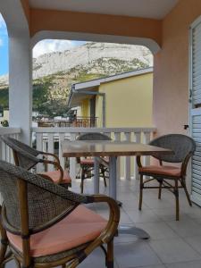 a table and chairs on a balcony with a mountain at House Vida Goraleks in Baška Voda